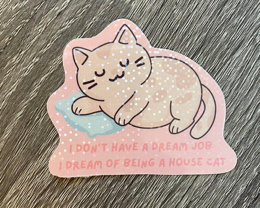 Sticker of a cat lying on a cloud with text on a wooden surface
